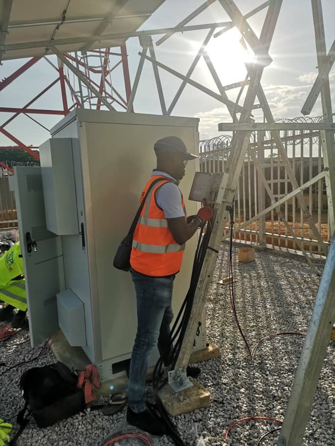 Technicien raccordant une armoire électrique sur site solaire